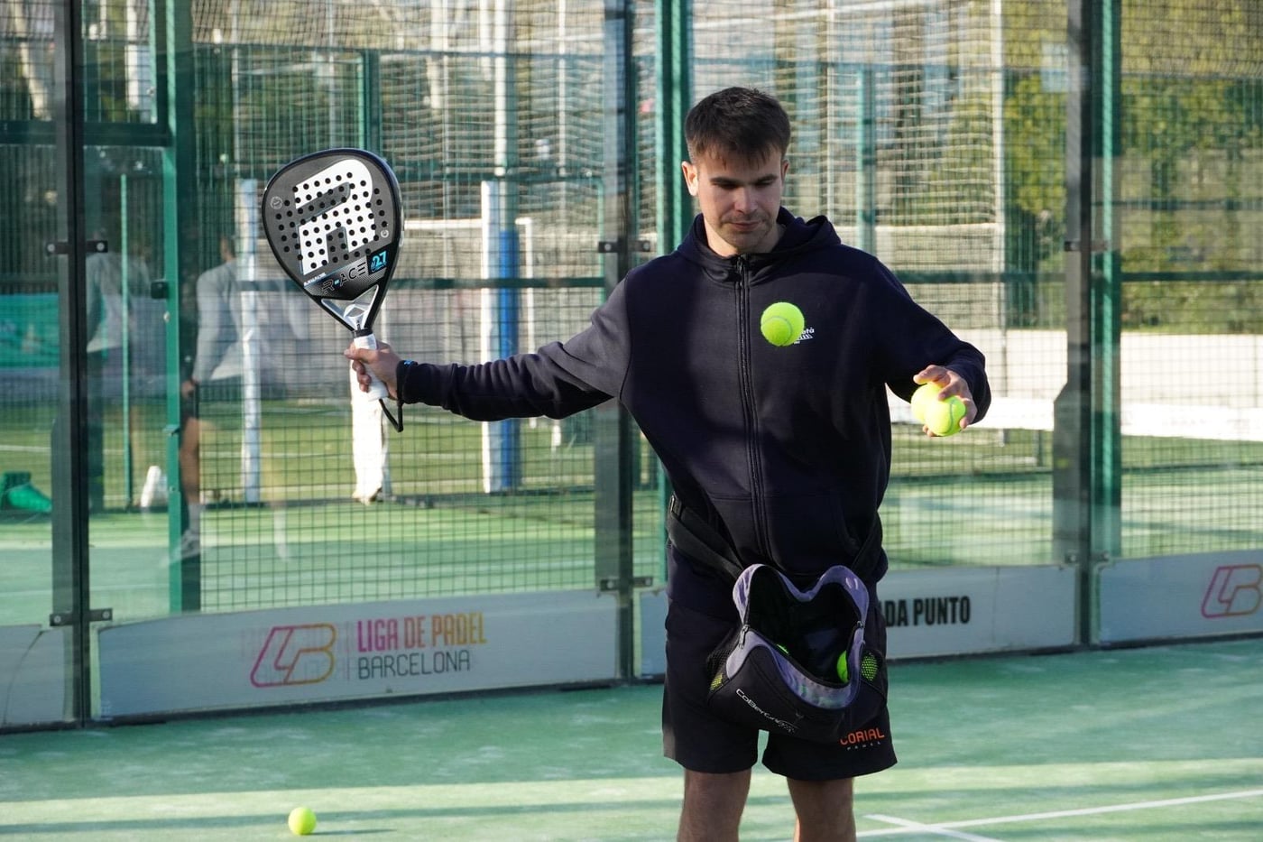 Max, head coach at Barcelona Padel Escapes, holding a racket and balls on court