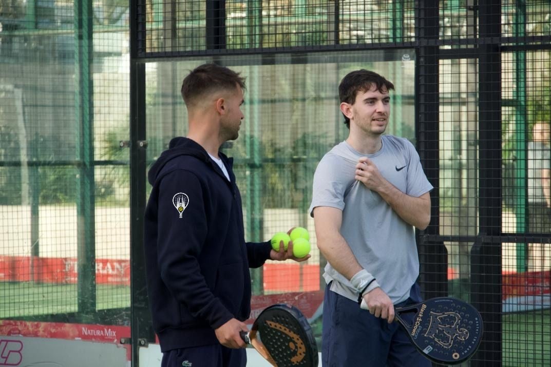 Max, head coach, chatting with a student on court after a session